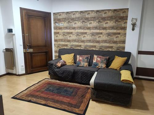 un sofá negro en una sala de estar con una pared de ladrillo en Happy Guest Apartments - Central Living Borno, en Borno