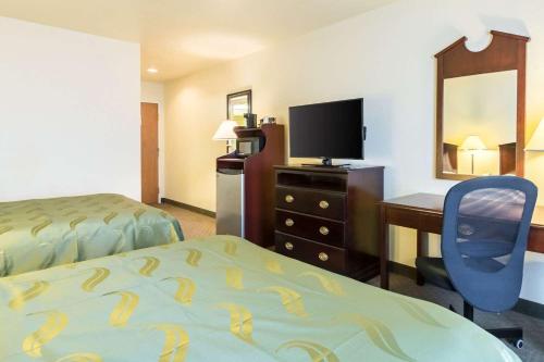 HOTEL VIP 46 SSQS في Bagua Grande: غرفة في الفندق بها سرير ومكتب وتلفزيون