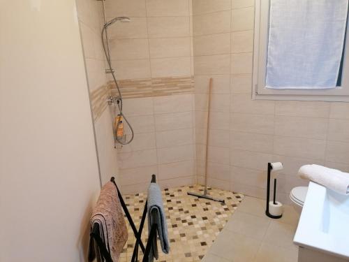 y baño con ducha y suelo de baldosa. en Chambre et table d'hôtes La Meule en Poligny