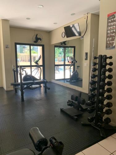 a fitness room with a gym with weights and a mirror at O Lugar! Apto no The Place in São José dos Campos