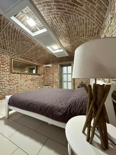 Un dormitorio con una cama y una pared de ladrillo. en 2х кім-й Loft на площі Філармонії by Willox, en Chernivtsi