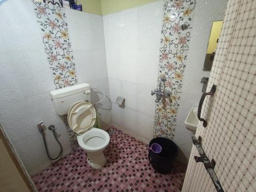 a small bathroom with a toilet and a shower at Regina Residency Inn in Palolem