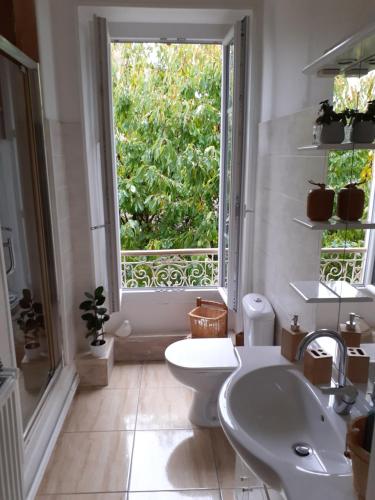 uma casa de banho com um WC, um lavatório e uma janela em La Caudalie 