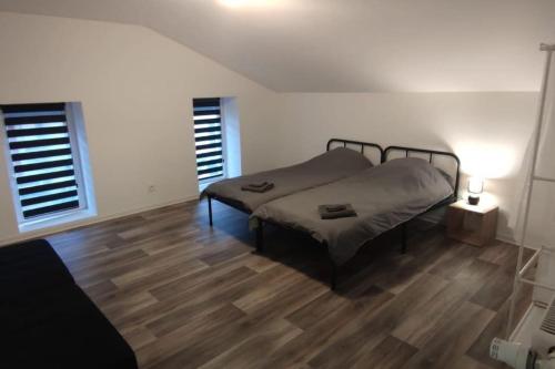 a bedroom with a bed and a wooden floor at Se relaxer dans la vallée in Hombourg-Haut