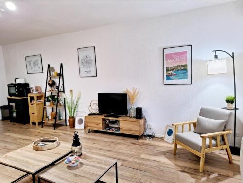 ein Wohnzimmer mit einem Sofa und einem TV in der Unterkunft Appartement Cosy Proche Gare - Fibre Optique et Parking in Angoulême