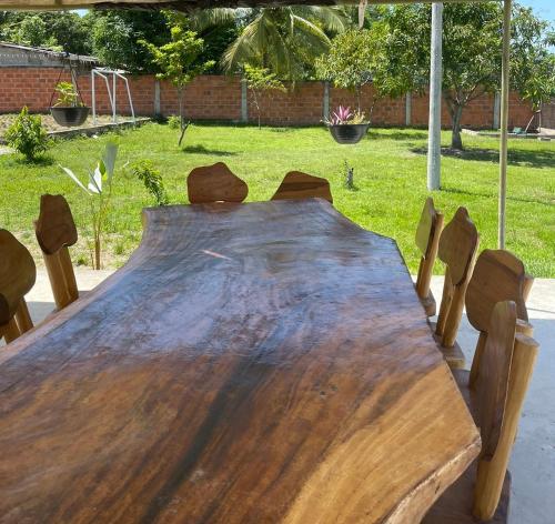 uma mesa de madeira num quintal com cadeiras à volta em Casa Campestre JO em Polonuevo