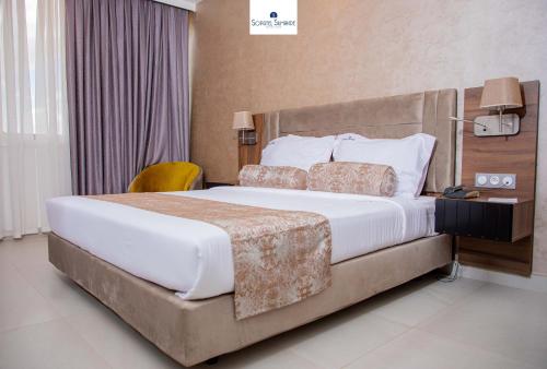 a bedroom with a large bed in a hotel room at Sopatel Silmandé in Ouagadougou