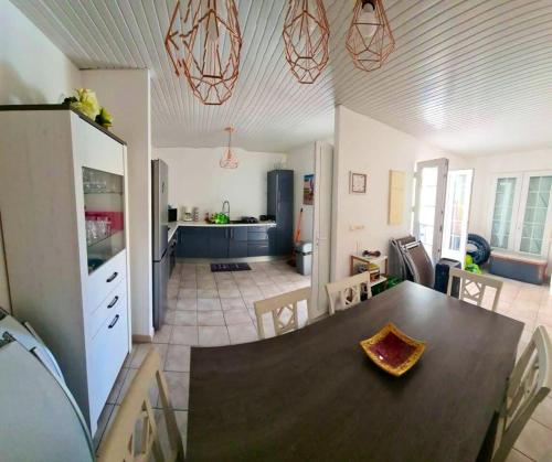 a kitchen and a dining room with a table in a room at Villa charmante au Diamant avec piscine privée in Le Diamant