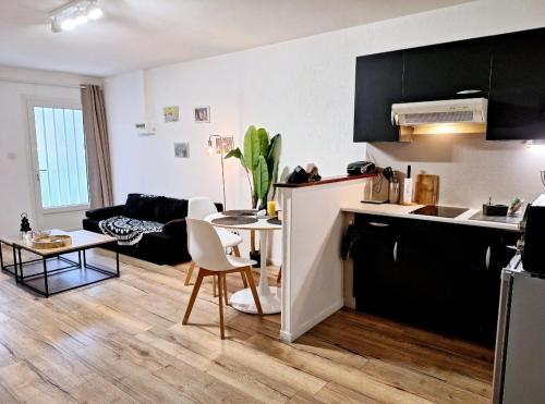 eine Küche und ein Wohnzimmer mit einem Tisch in der Unterkunft Appartement Cosy Proche Gare - Fibre Optique et Parking in Angoulême