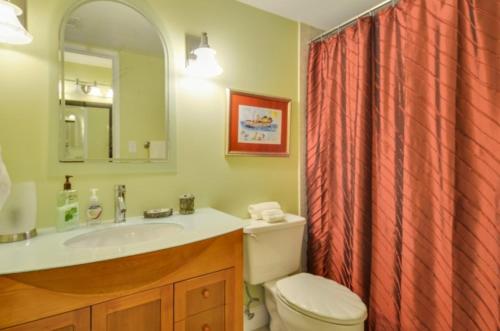 a bathroom with a sink and a toilet and a mirror at Palms 301 in Islamorada
