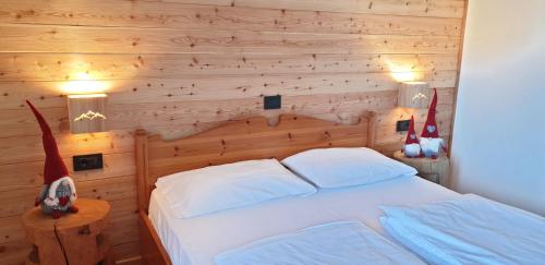 フォルガリーアにあるHotel Laresの木製の壁のベッドルーム1室(ベッド1台付)