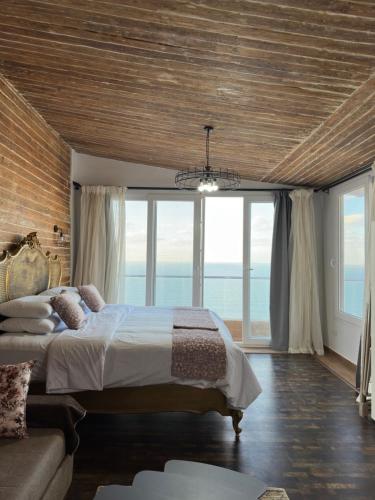 a bedroom with a large bed and large windows at Sea View Cabin in Alexandria