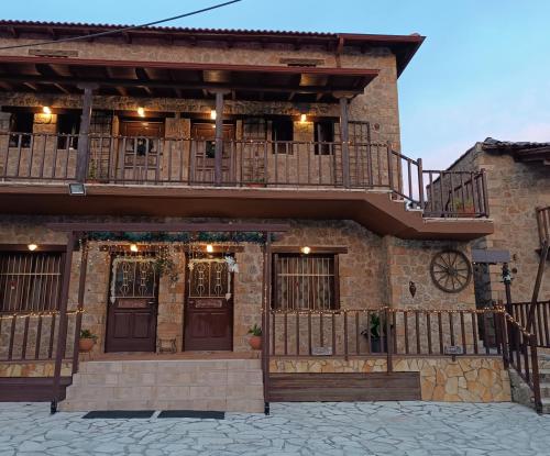 a building with a balcony on the side of it at Ξενώνας Λίκνο in Synikia Mesi Trikalon