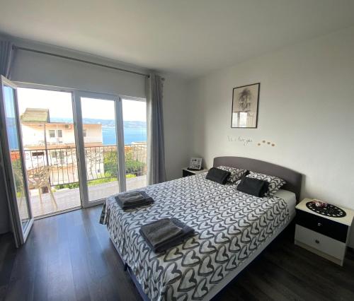 sypialnia z łóżkiem i dużym oknem w obiekcie Black and White Apartment - 2 bedrooms, walk to the beach w Duće