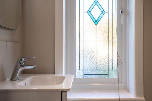 a bathroom with a sink and a window at A Piece of Seaside Serenity on the Sandbanks Peninsula in Sandbanks