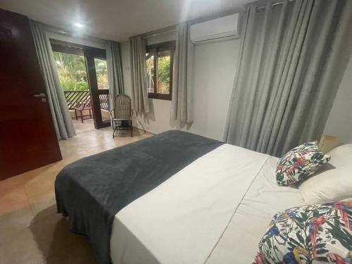 1 dormitorio con 1 cama y balcón en Pipa Beleza Chalé Particular, en Pipa