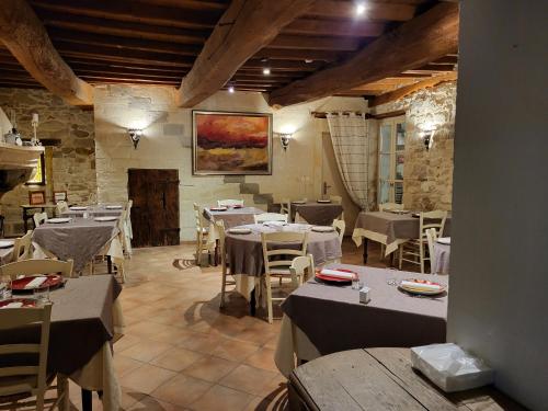 a restaurant with tables and chairs in a room at Logis Hotel la Ferme in Avignon
