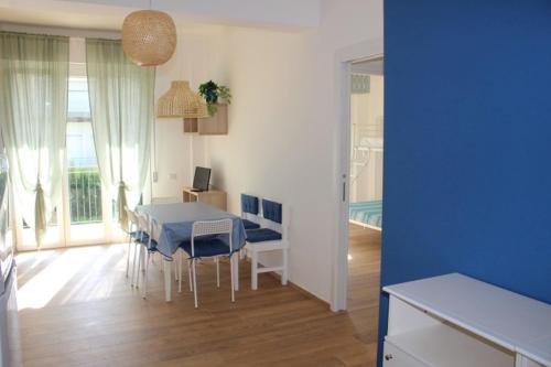 a kitchen and dining room with a blue table and chairs at Trilo Lorenzo - In centro ed a soli 30 m dal mare in Numana
