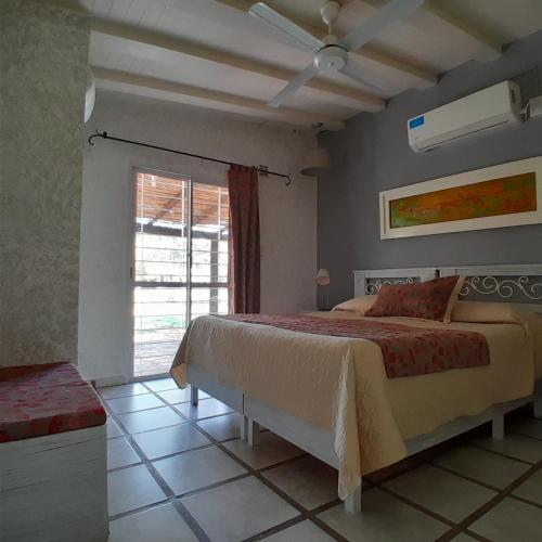 a bedroom with a large bed and a window at Estancia el Cimarrón in La Granja