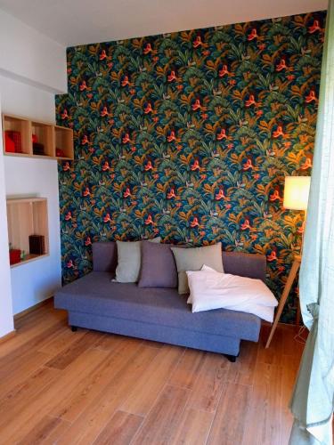 a couch in a living room with a large wall at Trilo Lorenzo - In centro ed a soli 30 m dal mare in Numana