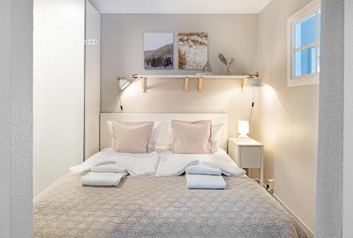 a white bedroom with a large bed with two pillows at Achtersteven in List