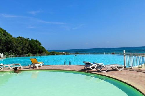 a large swimming pool with a chair and a chair at Domaine de l'Anse des Rochers in Saint-François