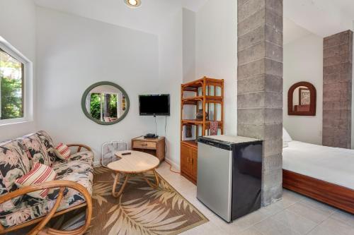 a living room with a couch and a bed and a table at Manini Beachfront Getaway in Captain Cook
