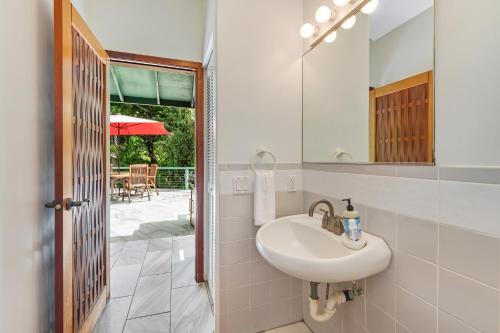 a bathroom with a sink and a mirror at Manini Beachfront Getaway in Captain Cook