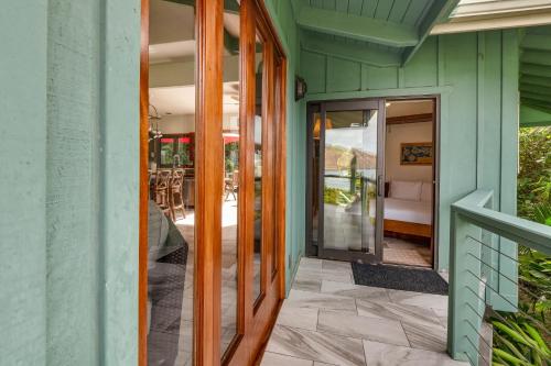 an open door of a house with a patio at Manini Beachfront Getaway in Captain Cook