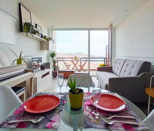 una sala de estar con una mesa con platos y gafas rojas en Terraza y piscina con vistas espectaculares al mar Parking cubierto, en San Vicente de la Barquera