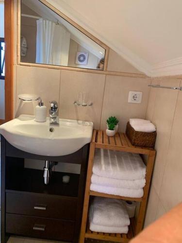 a bathroom with a sink and a mirror and towels at Cozy chalet with ocean view in Seixal