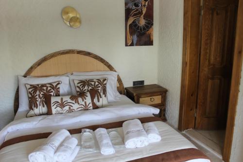 a bedroom with two beds with white towels on them at Aura Village Alaçatı in Alacati