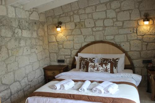 a bedroom with two beds in a stone wall at Aura Village Alaçatı in Alacati