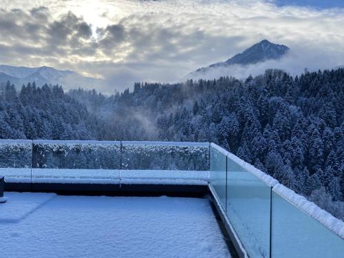 a snow covered balcony with a view of a mountain at Wohnung Staufenblick und Wohnung Firstblick in Dornbirn