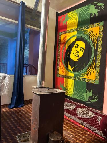 a painting of a man on a wall in a room at Tiny Spot Hostel in Manāli
