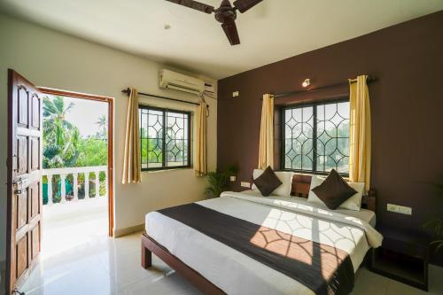 een slaapkamer met een bed en een groot raam bij Hotel Pasquina Baga in Baga