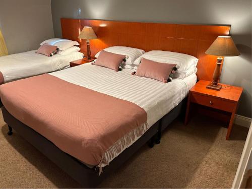 two beds in a hotel room with two lamps at Spacious 2 bedroom apartment in Killarney in Killarney