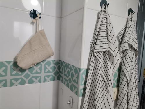 a bathroom with green and white tiles and towels at Villa Pepita in Almerimar