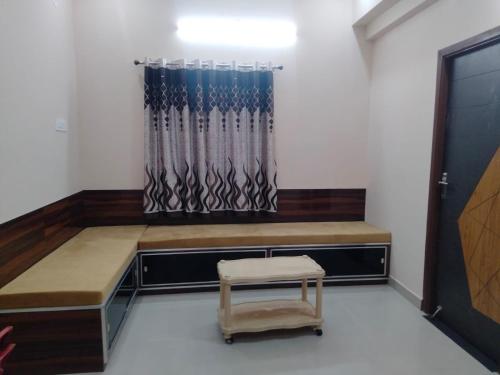 a room with a bench and a chair and a window at Alif Serviced (Hotel) Apartments in Tambaram