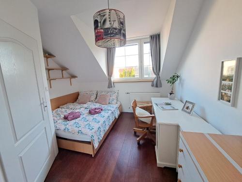a small bedroom with a bed and a desk at Family house with garden and sauna in Trnávka