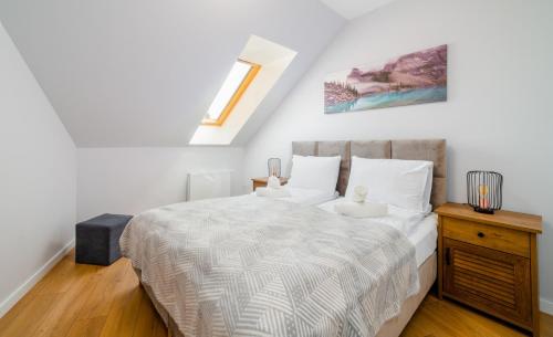 una camera da letto con un letto con lenzuola bianche e una finestra di Apartament Stone Hill - 8A37 a Szklarska Poręba