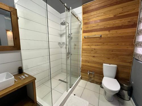 a bathroom with a toilet and a glass shower at Гостевой дом на Коктобе Люкс 5 in Almaty