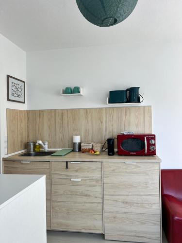 a kitchen with a red microwave on top of a counter at Maria Studio in Cascais