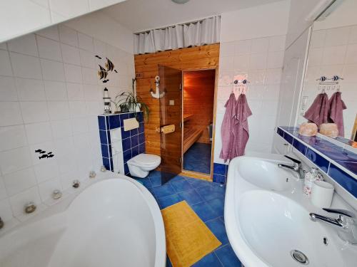 a bathroom with a tub and a sink and a toilet at Family house with garden and sauna in Trnávka