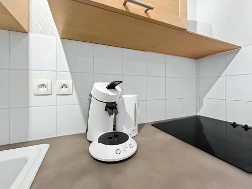 a white coffee maker sitting on a counter in a kitchen at La Douceur Richelieuse in Richelieu