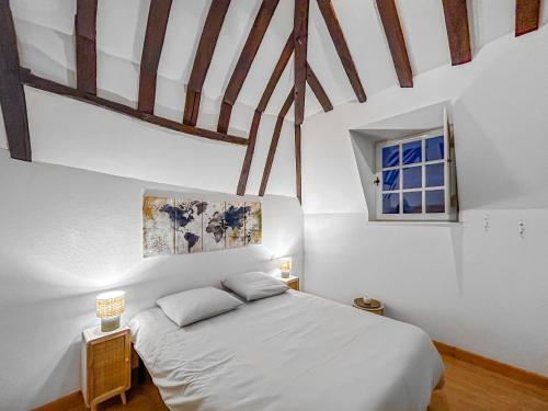 a bedroom with a white bed and a window at La Douceur Richelieuse in Richelieu