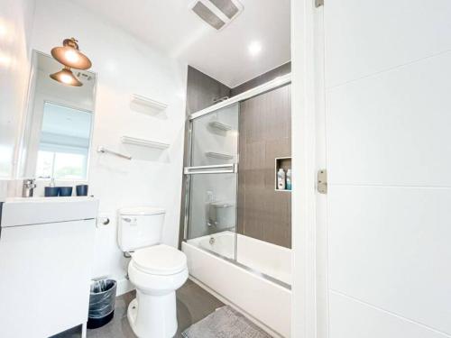La salle de bains blanche est pourvue d'une douche et de toilettes. dans l'établissement Ideal Townhouse in Mid City - CR1-CUL, à Los Angeles