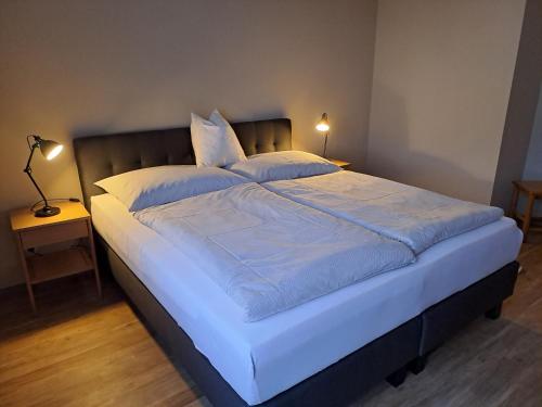 a large bed with white sheets and pillows on it at Haus Margrit Ferienwohnung in Sonnenlage in Golling an der Salzach
