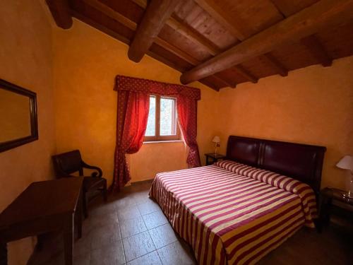 1 dormitorio con cama y ventana en La Casella antico feudo di campagna, en Ficulle