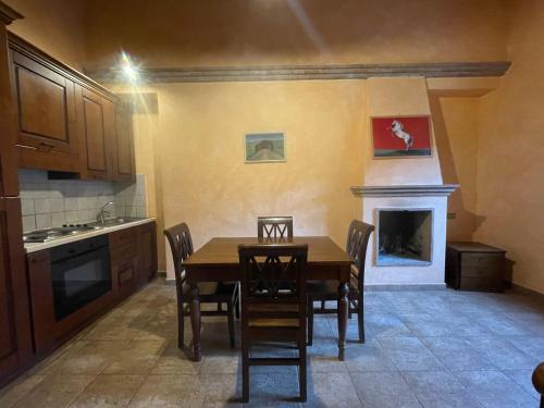 a kitchen with a wooden table and a fireplace at La Casella Antico Feudo di Campagna in Ficulle